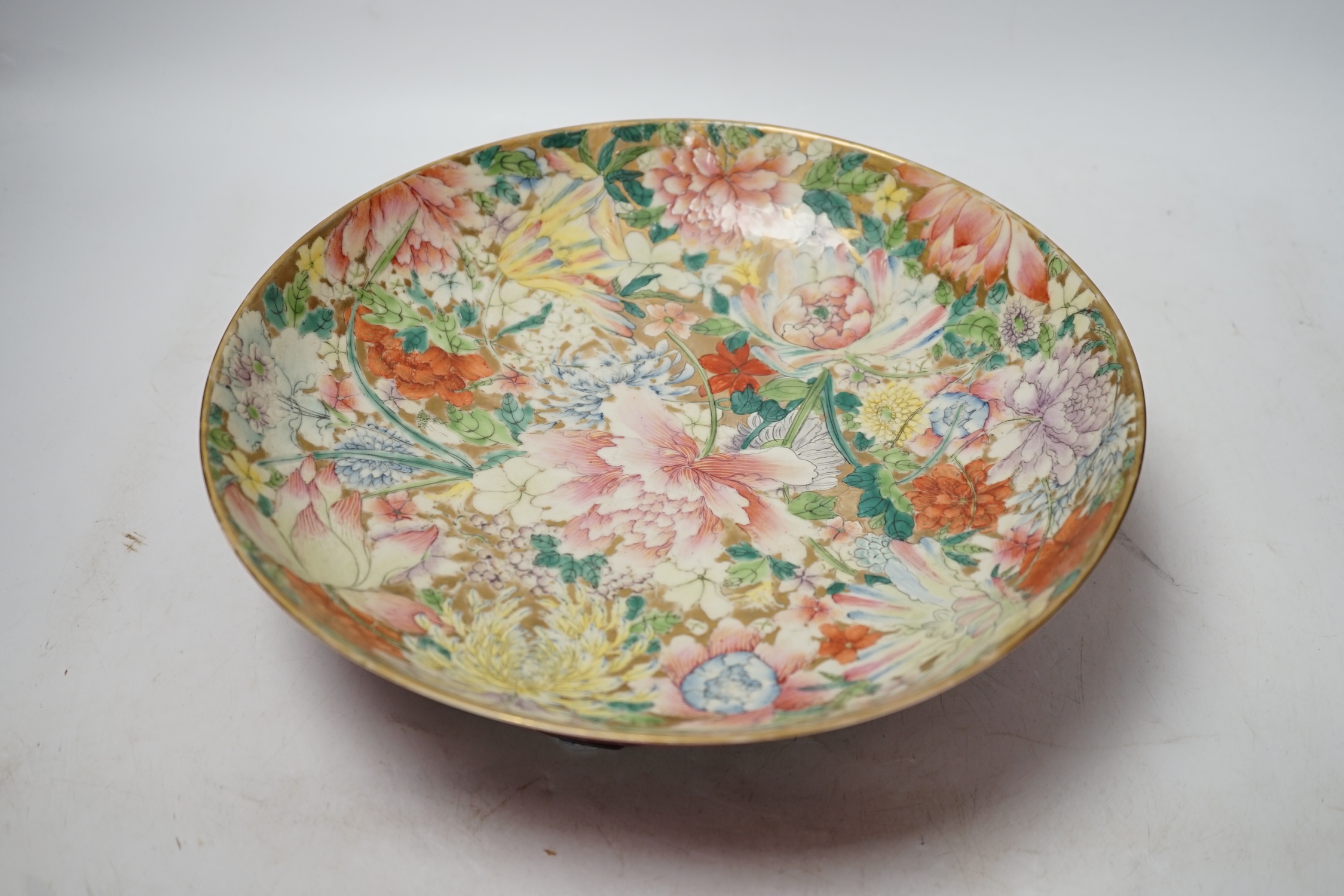 A Chinese enamelled porcelain millefleur dish, Guangxu mark and probably of the period, on wooden stand, diameter 28cm. Condition - restored